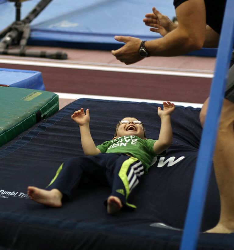 A photo of a happy client after landing on a Pit Pillow, supervised by a pediatric OT.