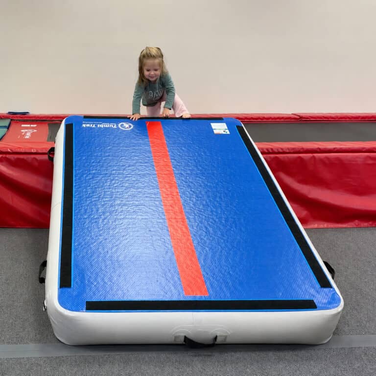 A photo of a girl in a pediatric OT clinic about to climb down a Power Launch which is propped like a ramp.