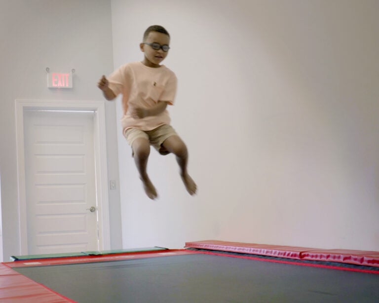 A photo of a boy bouncing on a Tumbl Trak.