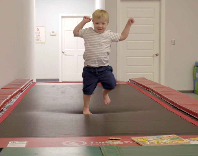 A photo of a boy joyfully walking on a Tumbl Trak.