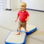 A boy at an OT clinic walks across two Hot Blocks.